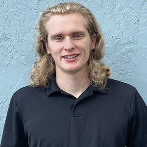 Picture of John "Jack" Williams with a ligh blue wall on the backgrund
